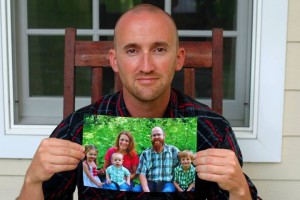 Josh holds picture of Jason Helm with his family.