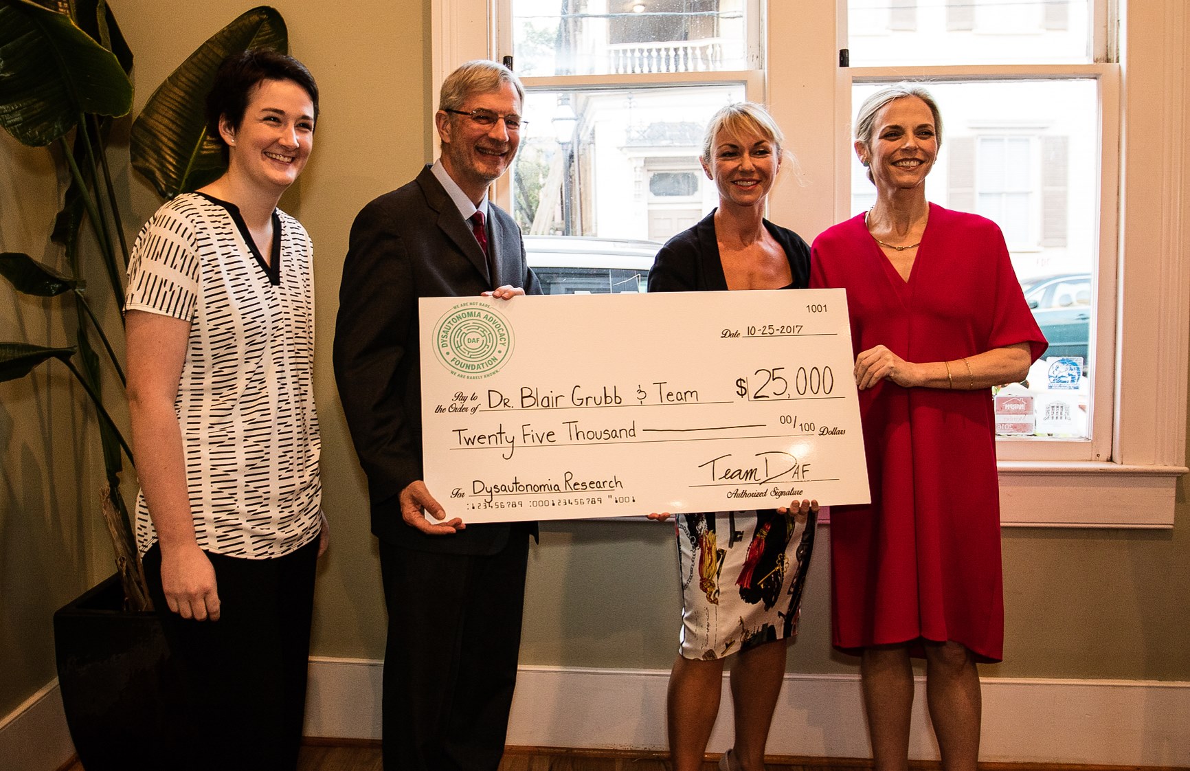 Sills (far left) presents Grubb his research grant in September of 2016.